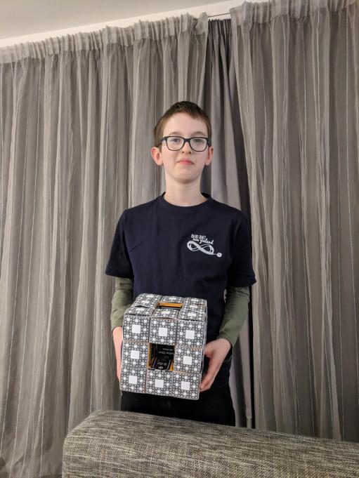 Tom holding a Menger-sponge model in his Maths Craft volunteer shirt